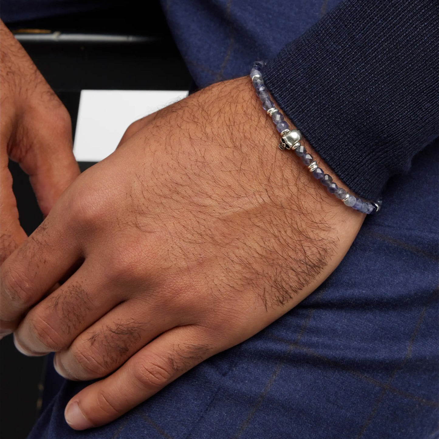 Male model wearing the Faceted Rutilated Quartz Gemstone Beaded Bracelet with Sterling Silver Skull by Jan Leslie of NYC.