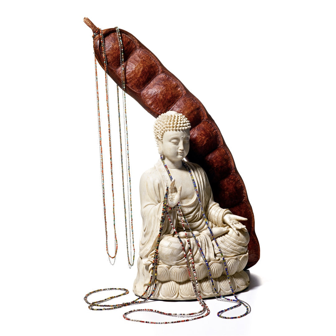 Multicolor Glass Bead Necklace with Sterling Silver Chain and Charm styled on a buddha statue.