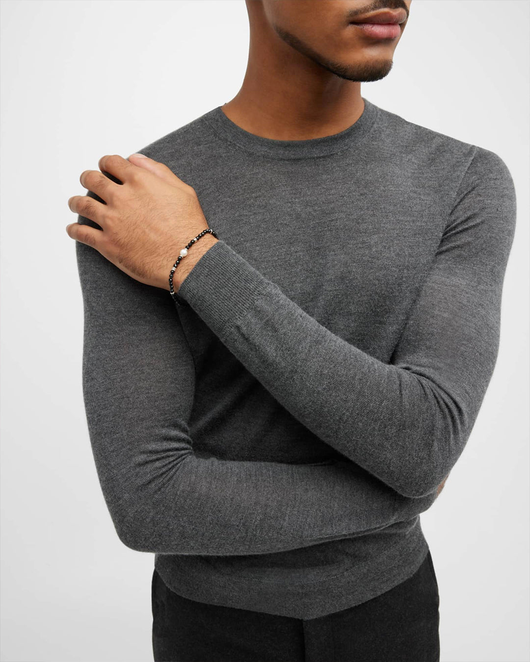Male model wearing the Men's Black Onyx Beaded Bracelet with Freshwater Pearl Center.