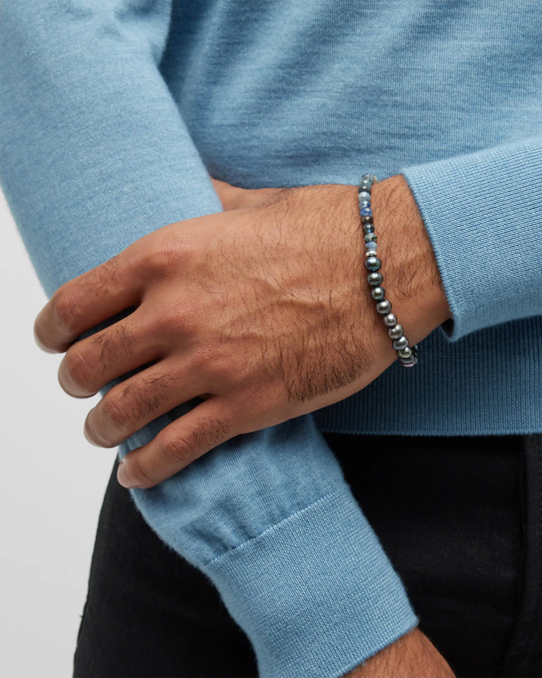 Close up of a male models wrist wearing the Blue Sapphire and Freshwater Pearls Split Beaded Bracelet. Jan Leslie Cufflinks and Accessories.