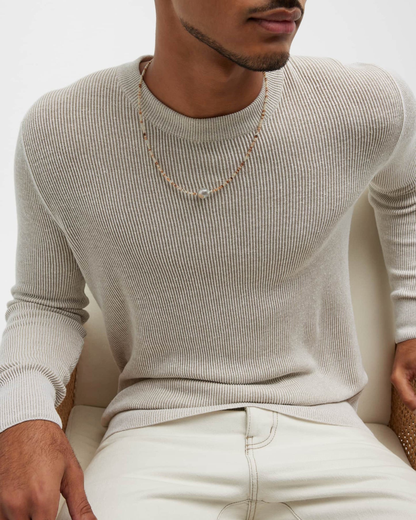 Photo of seated male models torso showing off the Freshwater Pearl Center White Shell Beaded Necklace with Sterling Silver Accents.