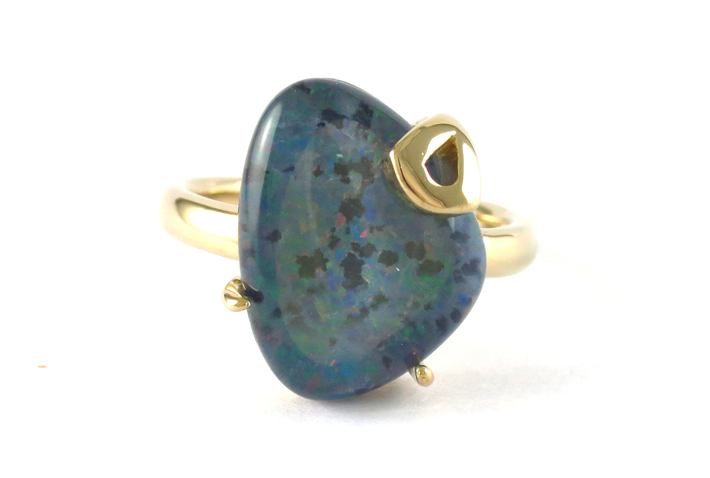 18k gold freeform black opal ring with a heart-shaped accent gemstone.