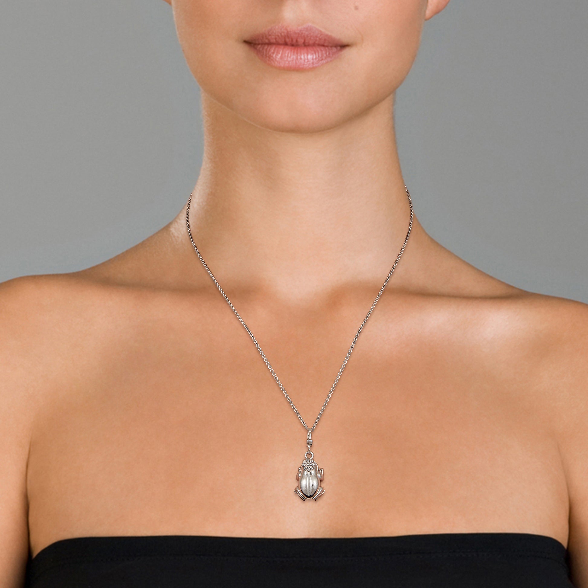 Close up of models neck wearing the Frog Prince Sterling Silver Charm Pendant.