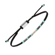 Adjustable black braided cord bracelet with hematite and turquoise tube beads, a sterling silver spiral charm centerpiece, and a 925 hallmarked sliding clasp.