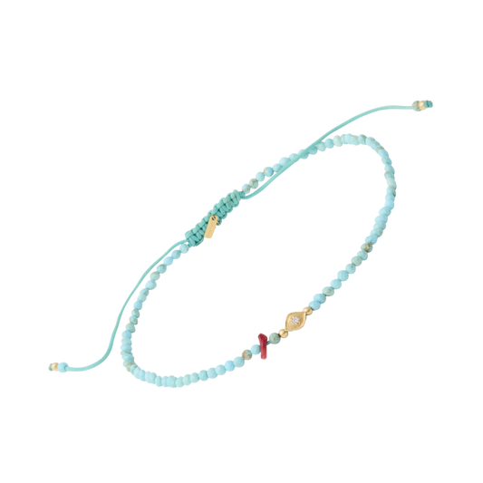 Handcrafted adjustable turquoise beaded bracelet featuring a gold evil eye charm, red coral accent, and macramé sliding knot closure — perfect for stacking or wearing solo."