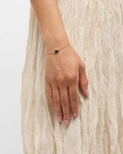 Woman wearing 18K gold vermeil malachite heart chain bracelet at wrist showing deep forest green natural malachite domed cabochon heart station on fine gold cable chain by Jan Leslie