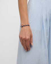Model in black knit dress wearing blue lapis heart link gold bracelet — Jan Leslie