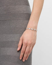Model in grey skirt wearing white mother-of-pearl heart link sterling silver bracelet — Jan Leslie