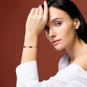 A delicate gold chain bracelet with three rectangular carnelian stone stations.