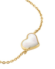Close-up of white mother-of-pearl heart bezel pendant on gold cable chain — Jan Leslie