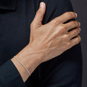 Man in navy knit jacket wearing round CZ bezel-set sterling silver tennis bracelet — Jan Leslie