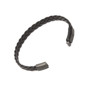 Open view of wide black braided leather cuff bracelet showing gunmetal flat magnetic snap clasp ends and herringbone weave.