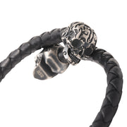 Close-up of the oxidized sterling silver tribal flame skull end cap on the black braided leather bracelet.