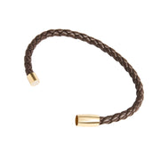 Close-up of dark brown braided leather bracelet showing gold cylindrical magnetic clasp ends open and unclasped.