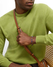 Men's mixed gemstone bead bracelet with lapis lazuli, red jasper, and rhodonite with gold spacers, styled with green sweater, Jan Leslie