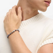 Iridescent gray baroque pearl bracelet with gold spacer beads on wrist.