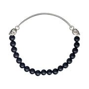 Men's matte black onyx bead bracelet with sterling silver ID bar and sculpted skull connectors