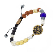 Adjustable multi-gemstone bracelet with antique brass coin centerpiece, rudraksha seeds, blue glass lotus, and mixed gemstone beads, Jan Leslie