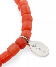 Close-up of engraved Jan Leslie signature oval charm tag on coral red glass tube bead bracelet, Jan Leslie