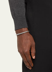 Man in gray sweater wearing an oxidized sterling silver herringbone woven open cuff bracelet on his wrist.