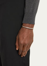  Man wearing sterling silver oxidized twisted rope open cuff bracelet on wrist with grey merino sweater and black trousers by Jan Leslie