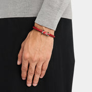 Man wearing sterling silver red enamel Formula 1 racing car clasp double-wrap red braided leather bracelet on wrist with grey knit sleeve by Jan Leslie