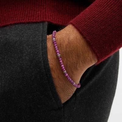 Close up of a male models wrist wearing the Jan Leslie Faceted Ruby Gemstone Bracelet with Black Pull Cord.