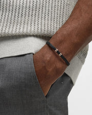 Men's matte black heishi bead bracelet with silver bar detail styled with grey mesh polo, Jan Leslie