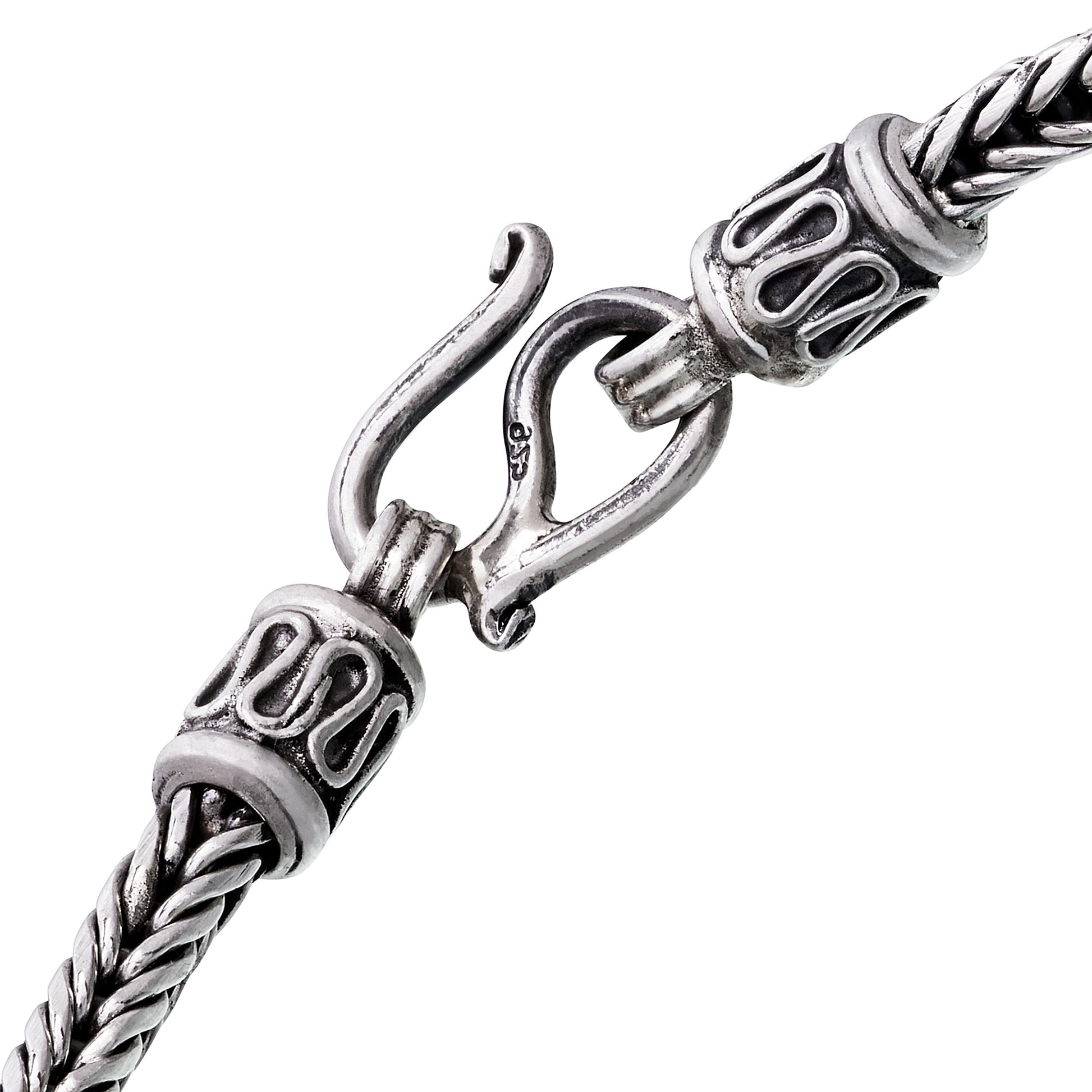 Close-up of oxidized sterling silver braided wheat chain bracelet showing decorative end caps and hook clasp with 925 hallmark by Jan Leslie.