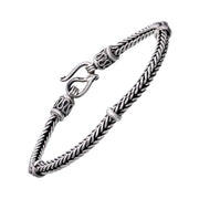 Oxidized sterling silver heavy braided wheat chain bracelet with decorative end caps ring accents and hook clasp showing full silhouette by Jan Leslie.