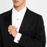 Man wearing sterling silver blue sapphire crystal tuxedo set showing shirt studs on pleated tuxedo shirt and cufflink on white dress shirt cuff with black tuxedo jacket by Jan Leslie.