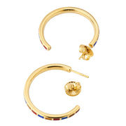 Small gold hoop earrings with multicolor enamel segment inlays, angled studio view — Jan Leslie