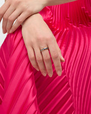 Lapis lazuli segment band ring in 18k gold vermeil worn on finger with hot pink pleated dress