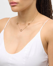 Model in white cami wearing multicolor enamel circle station necklace in gold at collarbone — Jan Leslie