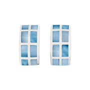 Pair of wide silver huggie hoop earrings with grid-pattern blue mother of pearl rectangular tile inlay, angled view