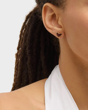 Model in white top wearing tiger's eye heart inlay gold stud earring, ear close-up — Jan Leslie