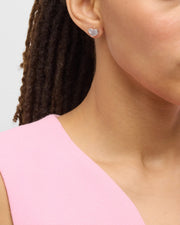 Model in pink top wearing white mother-of-pearl heart inlay sterling silver stud earring — Jan Leslie