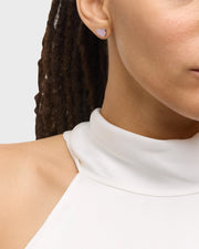 Model in white turtleneck wearing pink mother-of-pearl heart inlay silver stud earring — Jan Leslie