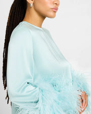 Woman wearing sterling silver blue enamel petal Seed of Life cutwork wide huggie hoop earring at lobe with mint aqua satin feather dress showing powder blue enamel ground and silver Seed of Life cutwork lattice by Jan Leslie