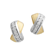 Two-tone crossover stud earrings with pavé diamond-set sterling silver band and polished gold panels.