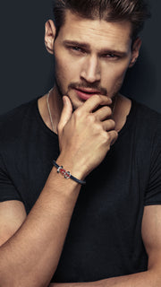 Man wearing sterling silver red enamel Formula 1 racing car clasp double-wrap black braided leather bracelet on wrist by Jan Leslie