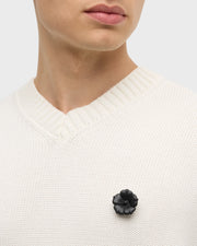 Model wearing white pearl sculpted flower lapel pin with crystal center on cream knit sweater vest by Jan Leslie.