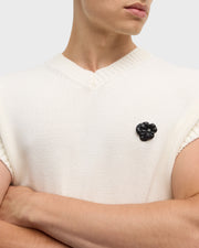 Model wearing clear crystal sculpted flower lapel pin on cream knit sweater vest close-up by Jan Leslie.