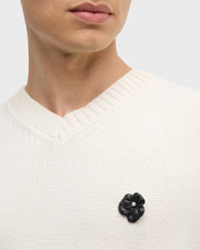  Model wearing white pearl sculpted flower lapel pin with crystal center on cream knit sweater vest by Jan Leslie