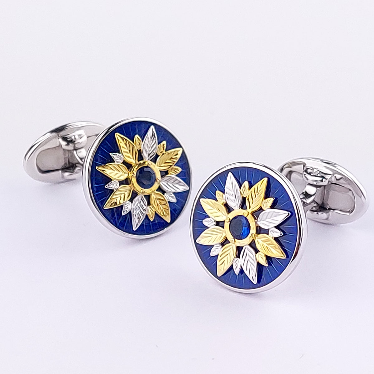 Round sterling silver cufflinks with cobalt blue enamel, gold vermeil sunflower motif, and blue sapphire crystal center. Jan Leslie