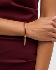Channel-set coral red square tile gold vermeil open cuff bangle bracelet worn on model's wrist