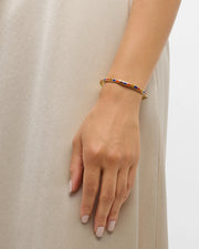 Model in dress wearing multicolor enamel tile gold bangle bracelet — Jan Leslie