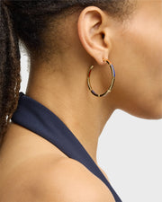 Side profile of model wearing large gold hoop earrings with white mother-of-pearl bar inlays — Jan Leslie