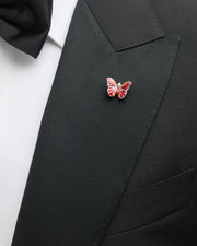 Red and coral enamel butterfly sterling silver lapel pin worn on black tuxedo