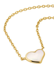 Close-up of white mother-of-pearl bezel heart pendant on gold cable chain — Jan Leslie
